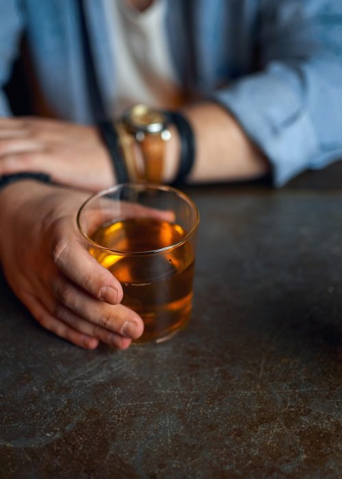 Drunk man pours alcohol at the counter in bar